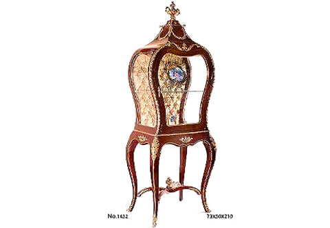 French ormolu mounted Serre-Bijoux after the model by François Linke and Léon Messagé, Circa 1904. Paris, The domed top with scrolling acanthus and reeds to the angles and surmounted by an engraved ormolu urn, above shaped bombé glazed sides ornamented with ormolu laurel wreath, the front with a door, the capitone golden velvet-lined interior with one glass shelves, on shaped tapering legs alternately headed by ormolu acanthus leaves, joined by a scrolled X shaped stretcher surmounted by a flower filled urn, on scrolled foliate cast sabots